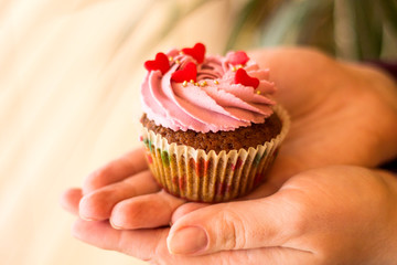 Cupcake decorated with cream and little hearts