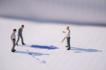 Business Direction concept. Group of businessman miniature figures standing, walking and standing on notebook with arrow signs under sunlight