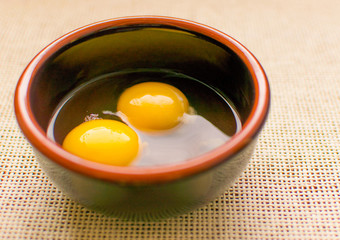 Raw chicken eggs in a plate .