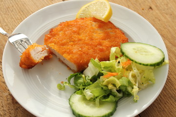 Angerichtetes Cordon Bleu mit Gabel auf Teller