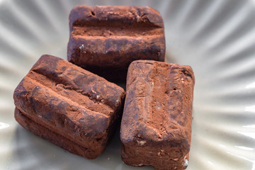 Italienische Trüffelpralinen - Tartufo dolce nero - auf weissem Hintergrund