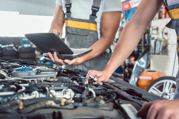 Close-up of a screwdriver held by a skilled mechanic, before repairing the engine after scanning...