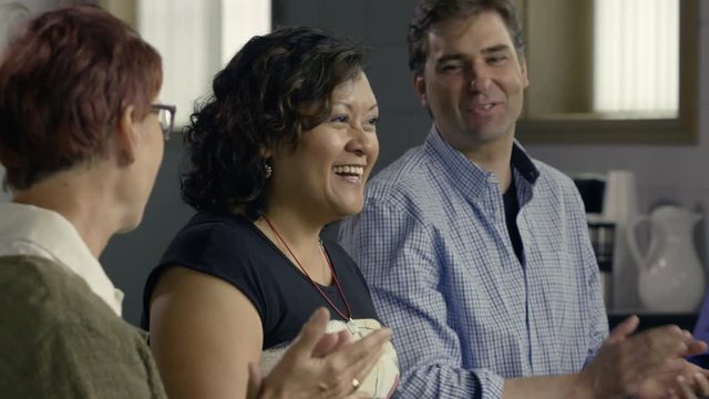 A woman shares her good news in a small group meeting