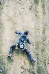 Obraz premium A man climbs the rock on a climbing route.
