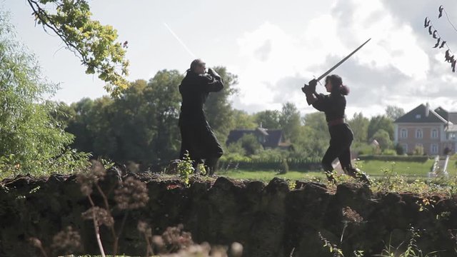 Man and woman are fighting sword on the bridge