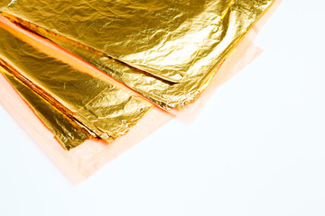 Pile of square gold leaf on white background