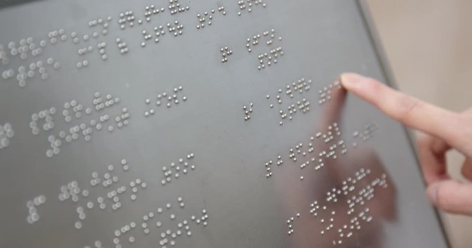 Blind reading on braille at outdoor