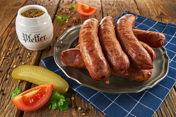 Tradycyjna polska kiełbasa na starym talerzu, na starych drewnianych deskach (styl rustykalny)