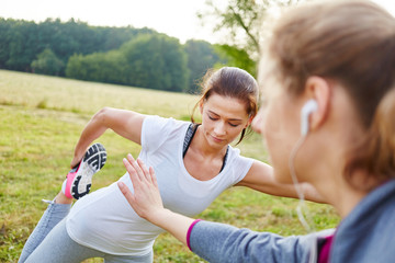 Frauen helfen sich beim Dehnen