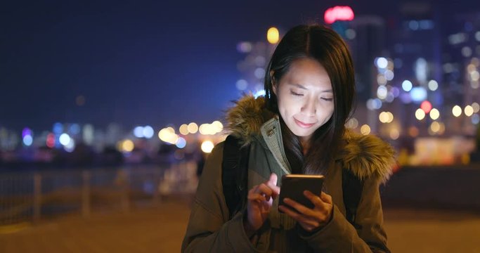 Woman use of smart phone in Hong Kong at night