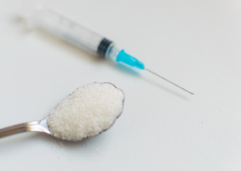 A spoonful of sugar and a syringe. The concept of harm to sugar and the onset of diabetes.