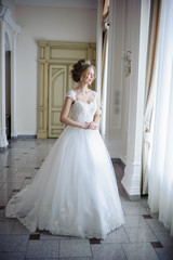 Fototapeta premium Beautiful bride in wedding dress before wedding ceremony in great hall