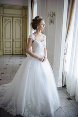 Fototapeta premium Beautiful bride in wedding dress before wedding ceremony in great hall
