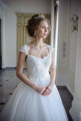 Beautiful bride in wedding dress before wedding ceremony in great hall