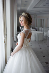 Beautiful bride in wedding dress before wedding ceremony in great hall