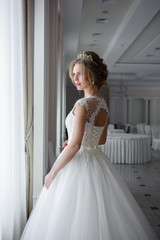 Fototapeta premium Beautiful bride in wedding dress before wedding ceremony in great hall