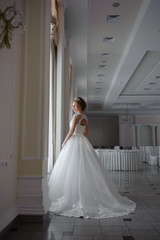Obraz premium Beautiful bride in wedding dress before wedding ceremony in great hall