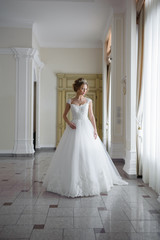 Fototapeta premium Beautiful bride in wedding dress before wedding ceremony in great hall