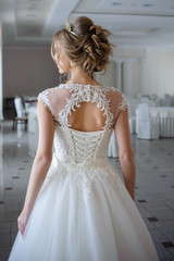 Fototapeta premium Beautiful bride in wedding dress before wedding ceremony in great hall