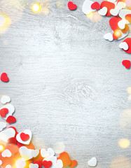 Beautiful romantic frame. Decorative red and white hearts on wooden background. View from above. Love and St. Valentines Day concept