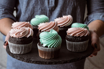 Tasty cupcakes on background table. Homemade chocolate muffin cupcake with cream buttercream icing. Birthday cupcake. Valentine cupcake sweets. Close up view delicious sweet dessert