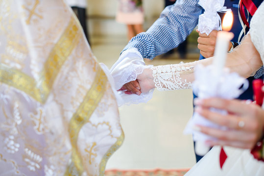 Bride and groom are holding each other's hands during church wedding ceremony
