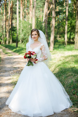 Fototapeta na wymiar wedding dress, wedding rings, wedding bouquet. Beautiful bride outdoors
