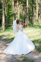 Fototapeta na wymiar wedding dress, wedding rings, wedding bouquet. Beautiful bride outdoors