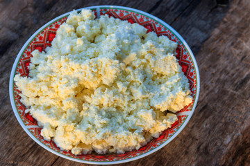 Homemade cottage cheese on old wooden table