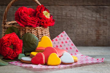 Gingerbread cookie hearts with garden roses over the wooden background. Valentine day postcard concept.