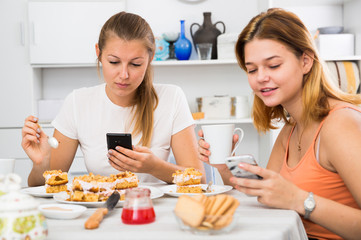 Obraz na płótnie Canvas friends drinking tea with mobile phone