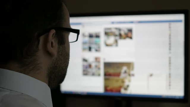 A man using on social networks. Businessman reads the news. Computer monitor showing blur Facebook news feed page young girl online.