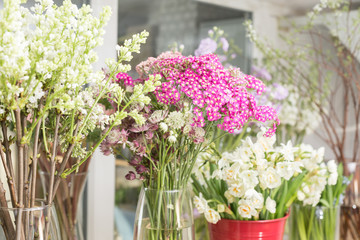 Flower shop concept. Different varieties fresh spring flowers in refrigerator room for flowers. Bouquets on shelf, florist business.