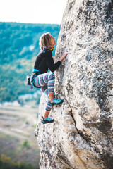 Fototapeta premium Girl climbs the rock.