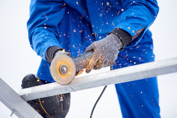 Cropped shot of a technician worker cutting steel on sonstruction site welding constructionist work profession occupation job craft metal metalworking industrial equipment tools.