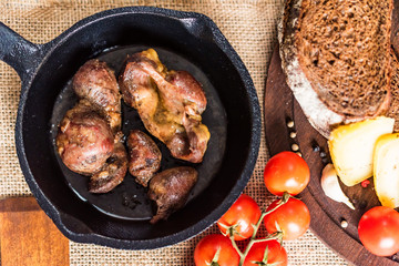 Top view roasted chicken giblets in pan and bread
