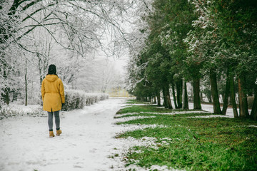 Fototapeta na wymiar woman walk by park where winter meet spring