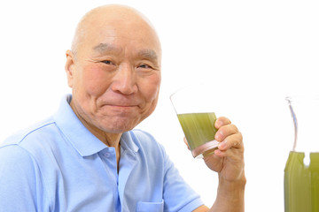 野菜ジュースを飲むシニア