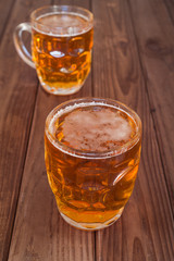 Beer mugs on wooden bar benches.