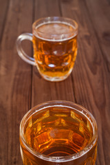 Beer mugs on wooden bar benches.