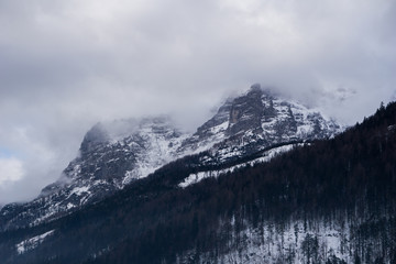 Obraz premium Spooky mountains scenery with alpine peak shrouded in fog and clouds