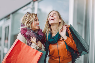 Happy friends shopping. Two beautiful young women enjoying shopping in the city.