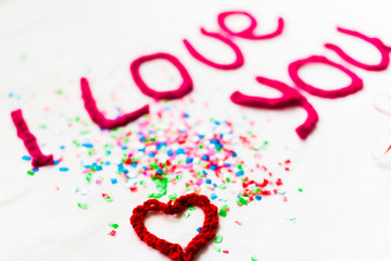 Inscription in knitted letters on a white background. St. Valentine's Day isolate