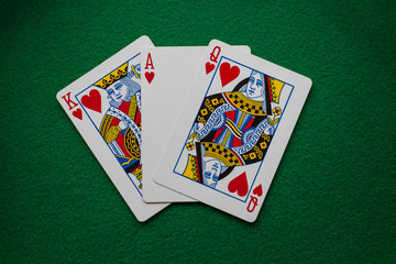King ace and queen of hearts on green felt
