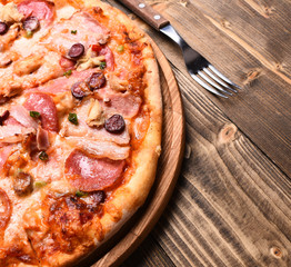 Pizza on wooden table with fork