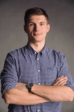 Portrait of smiling man in blue shirt isolated on gray studio background posing to the camera