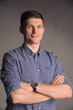 Portrait of smiling man in blue shirt isolated on gray studio background posing to the camera