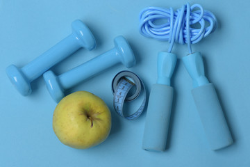 Jump rope, fruit, measure tape and barbells, topview