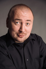 Obraz premium portrait of man in black shirt isolated on gray studio background posing to the camera