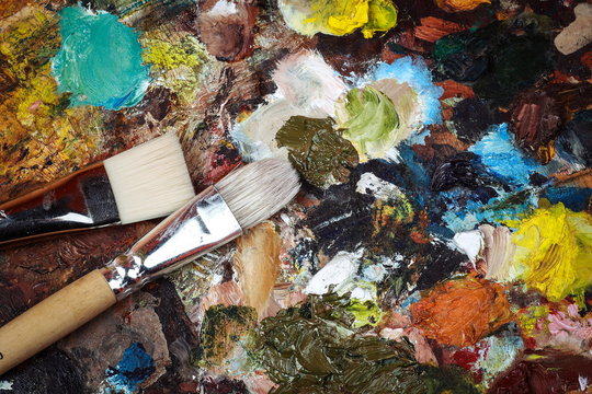 Макрофотография палитры искусства с красочными смешанными красками и щетками